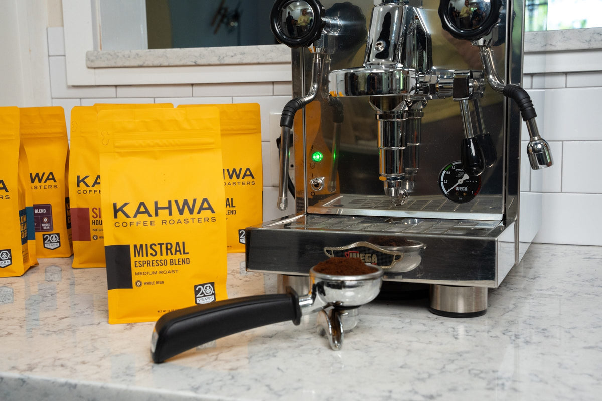 Kahwa Mistral espresso blend beside an espresso machine and portafilter