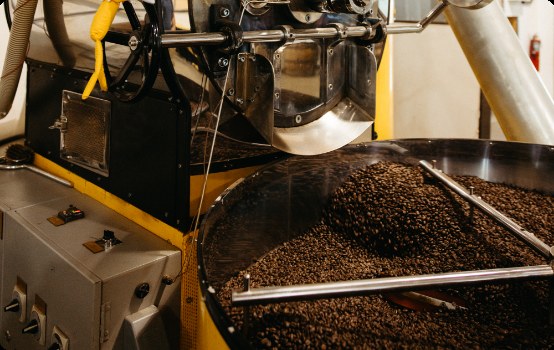 Coffee beans pouring from the drum of a Kahwa roaster