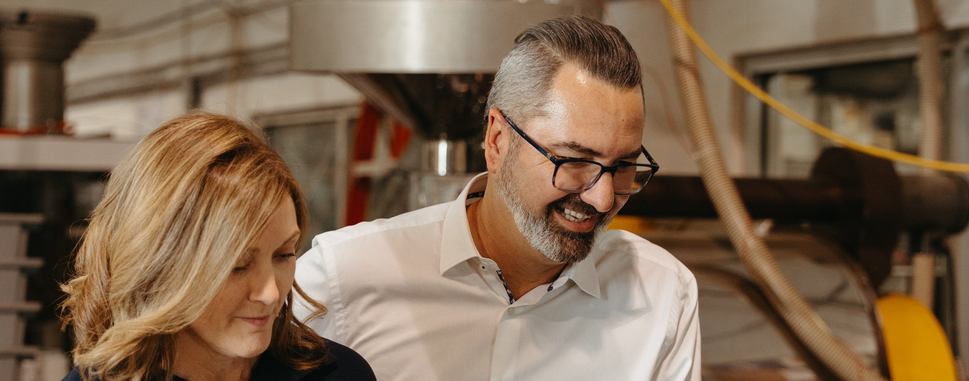 Kahwa Coffee Roasters co-founders Sarah and Raphael Perrier watching a batch of coffee beans finish in the cooling tray of the roaster at the Kahwa roastery in St. Petersburg, Florida