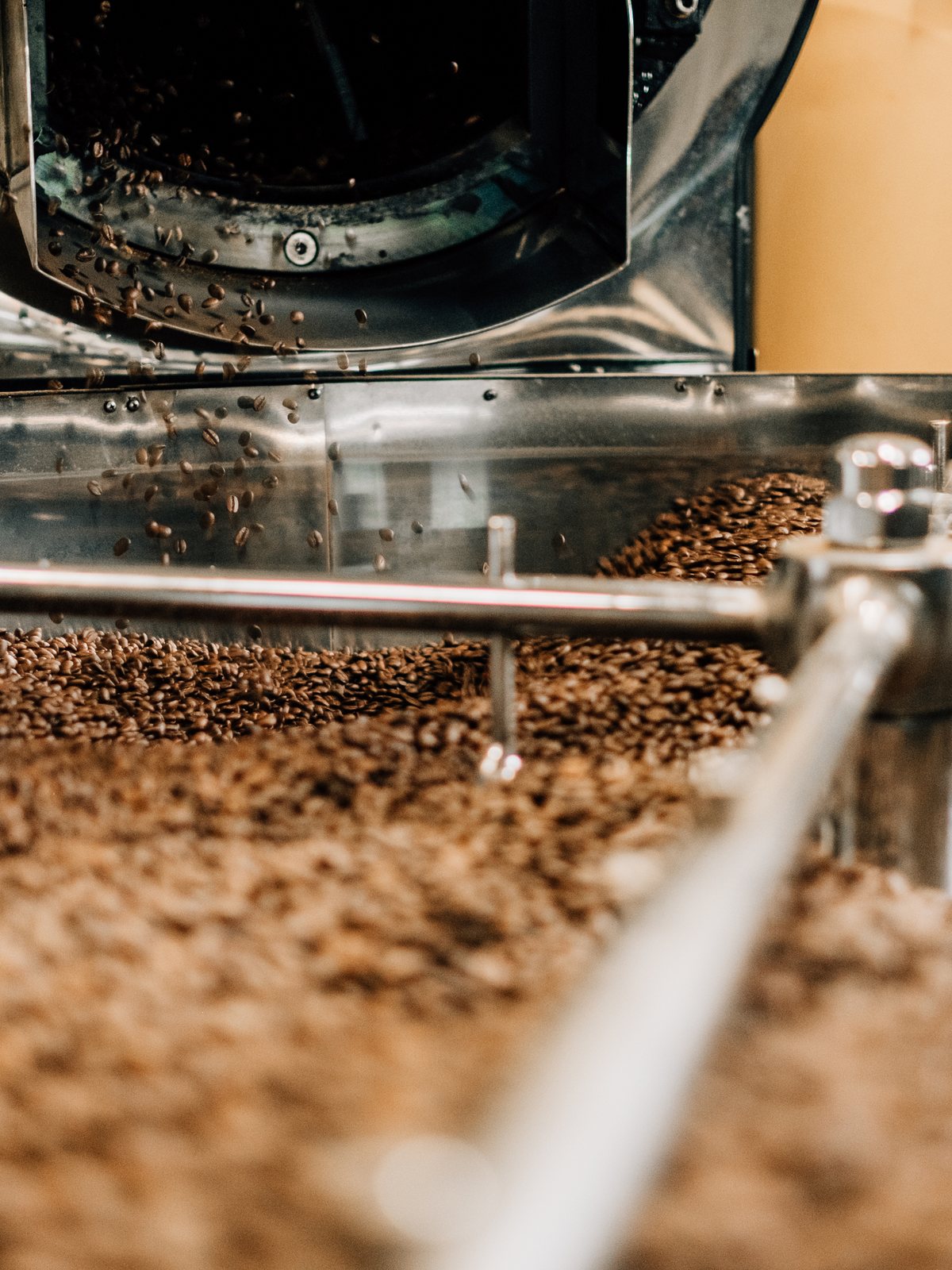 Coffee beans tumbling in a stainless steel roaster drum at Kahwa Coffee