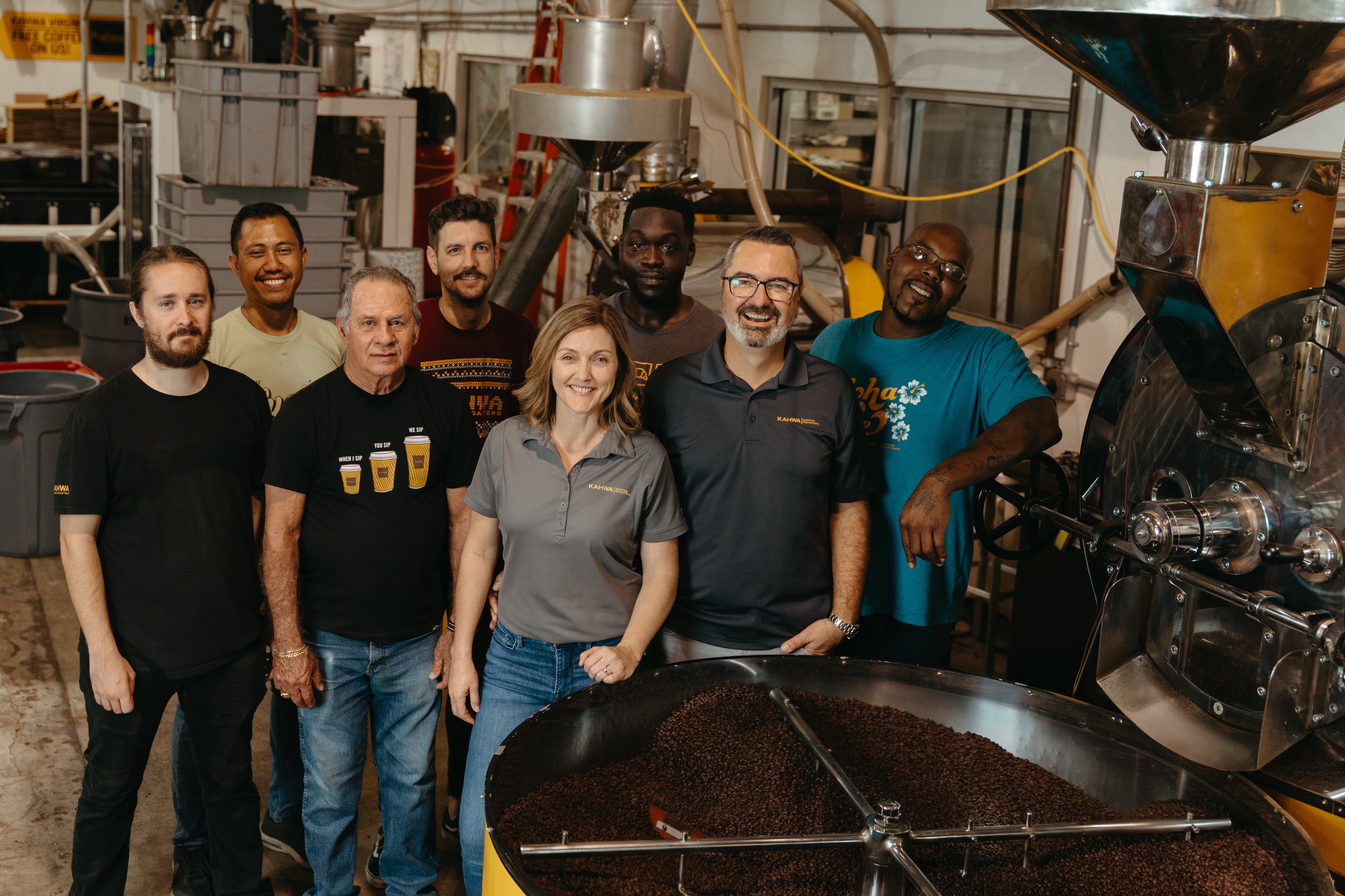 The Kahwa Coffee roasting team gathered around the cooling tray of the drum roaster at the St. Petersburg, Florida roastery